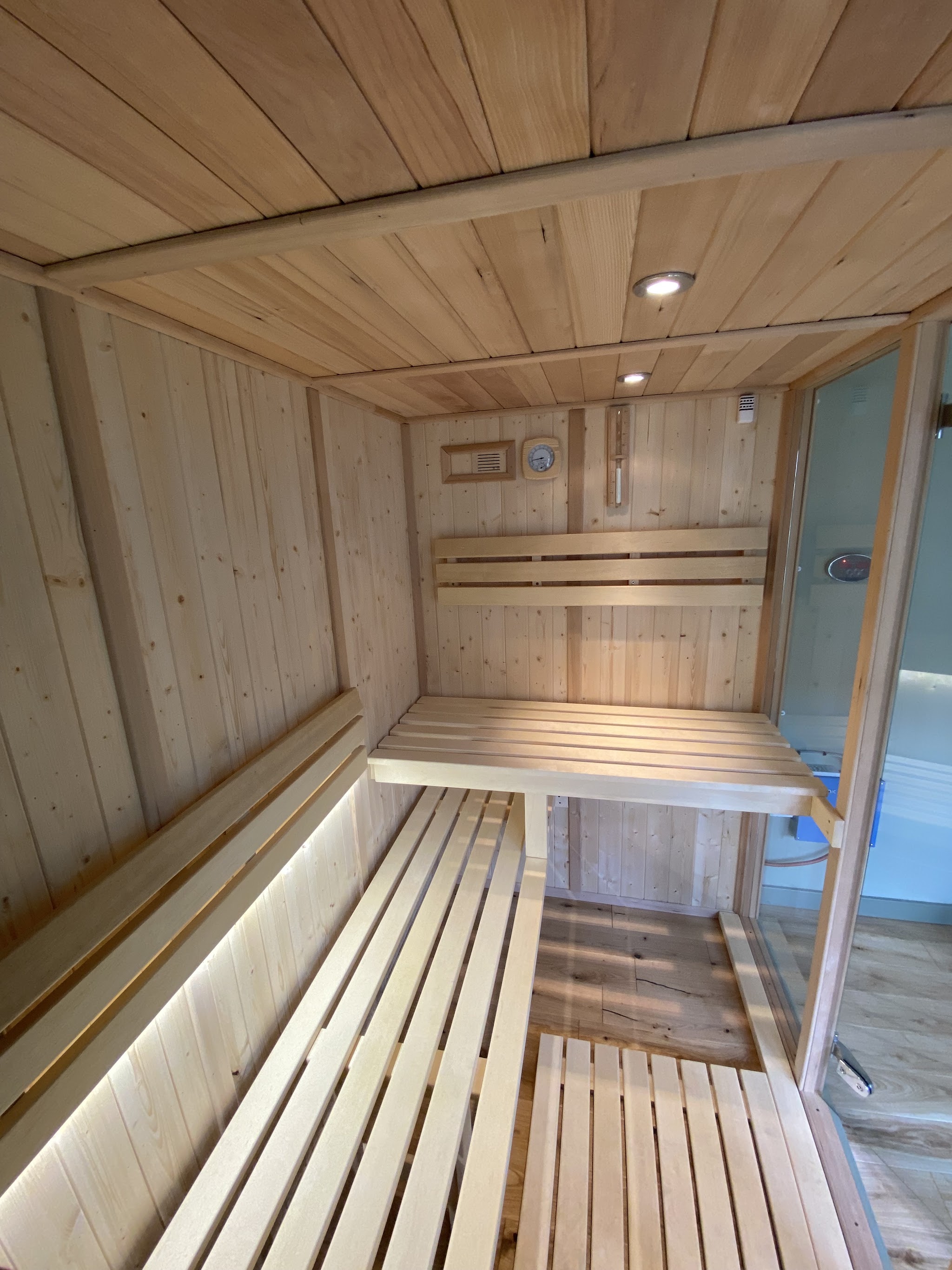 Timber sauna with LED strip lighting under the benches and a ceiling downlight